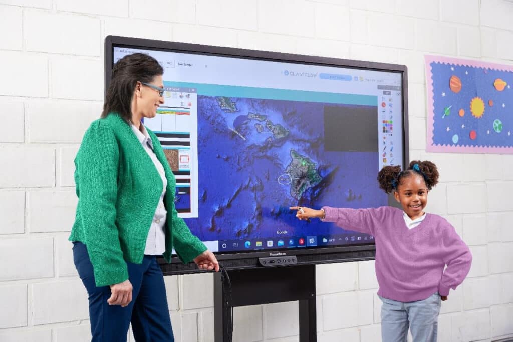 Cô giáo và học sinh đang tương tác với màn hình tương tác