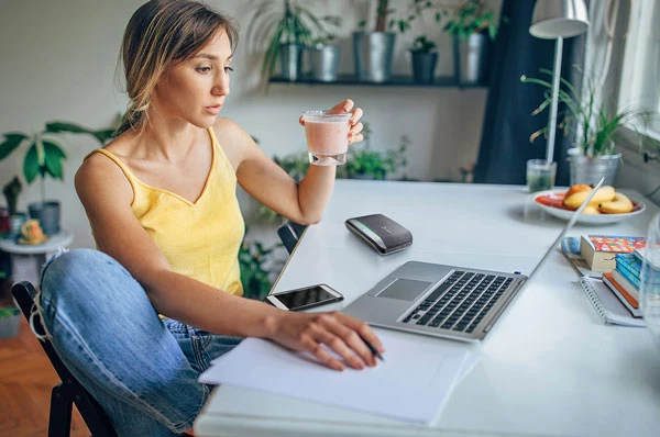 Một người phụ nữ làm việc với Poly Sync 20 đặt trên bàn