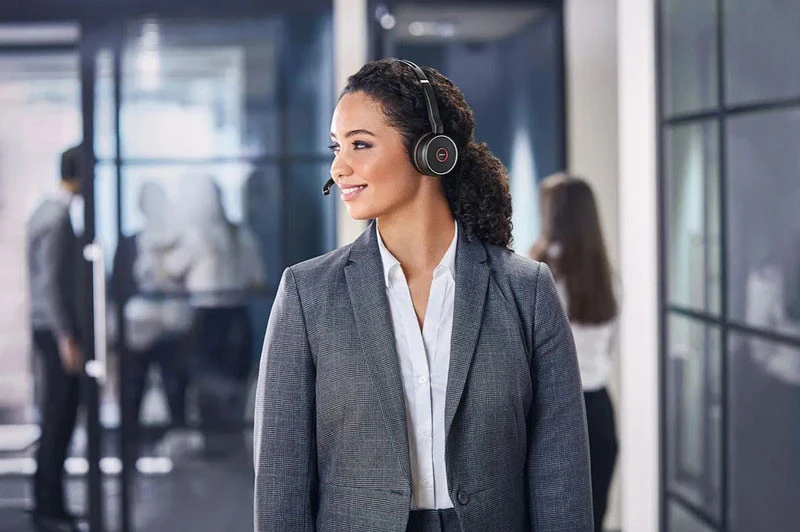 Một phụ nữ đang đeo tai nghe có mic tốt cho laptop của Poly