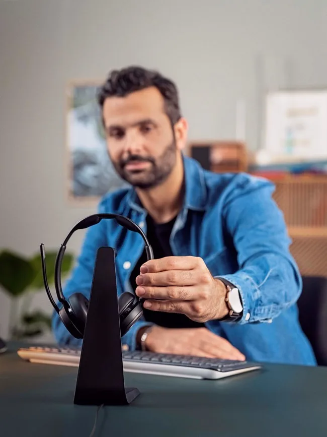 một người đàn ông đang sạc tai nghe epos impact 1000 series